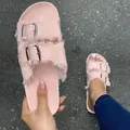 Close-up view of pink frayed canvas slides with double metal buckles on asphalt. - Pink