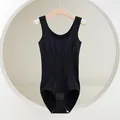 Seamless black shapewear bodysuit for tummy control, front view on a wooden hanger. - XS/S / Set / Black