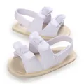 Primo piano di sandali bianchi per neonati con fiocchi doppi e suole in tessuto morbido - Lunghezza Interna 11cm / Bianco