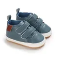 Close-up detail of blue PU leather baby walking shoes featuring anti-slip white rubber soles. - Blue