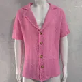 Detail of men's pink hollow knit shirt showing textured herringbone pattern and buttons - M / Tops / Pink