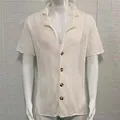 Detailed view of white men's hollow pointelle knit shirt featuring lapel and button closure. - M / Tops / White
