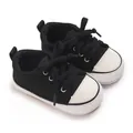 Vue rapprochée de baskets classiques noir et blanc à semelle souple pour bébés et nourrissons - Noir