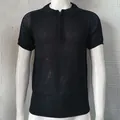 Close-up of men's slim fit knitted polo shirt with black mesh texture and zipper collar. - Black