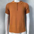 Vista dettagliata della trama in maglia della polo uomo slim arancione con mezza zip frontale - Taglia M / Top / Marrone
