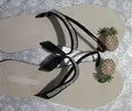 Dettaglio dei cinturini in strass e del decoro a forma di ananas con perle sui sandali piatti. - 35 / Nero