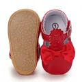Detail view of red baby princess shoes showing non-slip soft sole and bow - Red