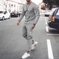 Detailed view of grey long-sleeved sweatshirt and matching joggers set on model. - S / Top And Bottom / Gray