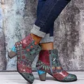 Vintage bunte Patchwork-Stiefeletten mit blauen Jeans vor einer rustikalen Texturwand - Navyblau und Rot