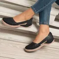 Detailed view of black laser-cut hollow-out flat casual sandals for women on wooden steps - 35 / Black