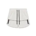 Detailed view of men's athletic shorts with black drawstrings and zipper pockets - Grayish White