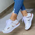 Primo piano di sneaker platform bianche con dettagli in oro rosa e lacci. - Bianco