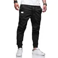 Vista detallada de pantalones joggers negros ajustados de algodón para hombre con puños. - Negro