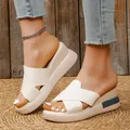 Elegante cremefarbene Keilsandalen mit Kreuzriemen in der Detailansicht am Modellfuß - Gebrochenes Weiß