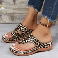 Detailed view of women's leopard print wedge thong sandals on feet for beach wear - 35 / Leopard Print