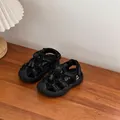 Close-up of black children's sports sandals with hollow-out design on wooden table - Size 32 Inner Length 20cm / Black