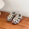 Detail view of colorful children's hollowed beach sandals on a wooden surface - Size 32 Inner Length 20cm / Camouflage