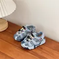 Detailed view of children's blue hollow sport sandals on a natural wood surface - Blue