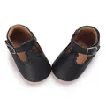 Close-up of black faux leather baby shoes with scalloped edges and T-strap buckle - Inner Length 11cm / Black