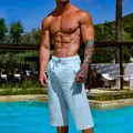 View of men's breathable light blue linen cotton cropped pants shown in a poolside setting - S / Bottoms / Light Blue