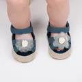 Primer plano de zapatos de bebé azul marino con detalle de flor blanca en los pies. - Azul