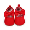 Vista superior de zapatos rojos de princesa para bebé con un lazo grande y forro floral - Rojo