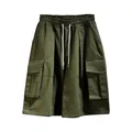 Detail view of olive green oversized cargo shorts with adjustable drawstring waist. - S / Bottoms / Army Green
