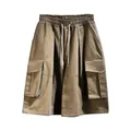 Front view detail of khaki oversized cargo shorts with drawstring waist and pockets - S / Bottoms / Khaki