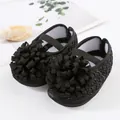 Nahaufnahme der eleganten schwarzen Baby-Prinzessin-Schuhe mit großen Rüschenblumen. - Größe 12 (Innen 11cm) / Schwarz