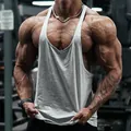 Detailansicht eines grauen Baumwoll-Stringer-Tanktops an einem muskulösen Fitnessmodell. - M / Oberteile / Hellgrau