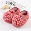 Gros plan de chaussures de princesse roses en maille pour bébé avec une grande fleur en ruban - Rose Clair