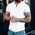 Detail view of a white men's slim fit Henley shirt featuring a buttoned placket. - S / Tops / White