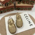 Dettaglio dei sandali intrecciati con glitter dorati per bambini dal design traforato - Oro Scintillante