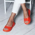 Detail van levendige oranje platform sandalen met open teen voor een zomerse look - Oranje