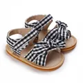 Close-up of black and white gingham baby sandals with a cute decorative bow ornament - 11cm / Black