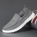 Grey slip-on canvas loafers for men featuring breathable fabric and soft white soles. - Gray