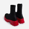 Rear view of black fly-knit breathable sock boots with chunky red platform sole. - Black Red