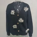 Dettaglio del cardigan in maglia nera con ricami floreali 3D e bottoni in stile vintage - Nero
