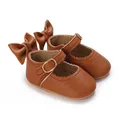 Close-up of brown baby Mary Jane shoes with back bows and scalloped edges. - Tan
