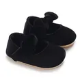 Detail view of black velvet baby princess shoes with a soft sole and large bow - Black