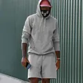 Primer plano de un conjunto de sudadera con capucha y pantalones cortos para hombre - Gris claro