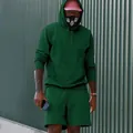 Modelo con conjunto de sudadera con capucha y pantalones cortos de forro polar verde - Verde Oscuro