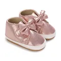 Vue détaillée de jolies chaussures de marche rose pailleté pour bébé fille avec un grand nœud - Rose
