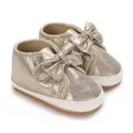 Détail de chaussures bébé fille pailletées dorées avec nœud élégant et semelle souple - Or