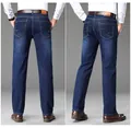 Back view of classic dark blue straight-leg men's jeans in a professional studio setting. - 28 / Bottoms / Blue