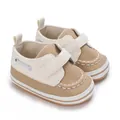 Vista ravvicinata di scarpine primi passi per neonati con suola morbida e velcro beige - Bianco