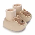 Nahaufnahme von süßen beigen Baby-Lauflernschuhen mit flauschigen Hasen-Patches. - Aprikose Hase