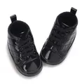 Nahaufnahme schwarze Lackleder-Baby-Lauflernschuhe mit feinem Steppmuster-Detail - Schwarz