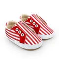 Détail de chaussures de marche pour bébé à rayures rouges et blanches avec semelles. - Rouge