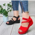 Detailansicht von roten und schwarzen Damen-Keilsandalen mit Schleife und Plateau - Rot
